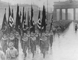 Miembros de las Tropas de Asalto (SA) marchan a través de la puerta de Brandenburgo.