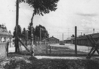 An early view of the Dachau concentration camp. Columns of prisoners are visible behind the barbed wire.
