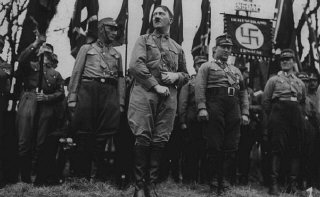 Adolf Hitler stands with an SA unit during a Nazi parade