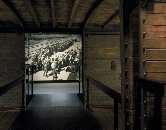 View of the photo mural of a selection at Auschwitz-Birkenau taken through the open railcar on the third floor of the Permanent Exhibition ... [LCID: n02433]