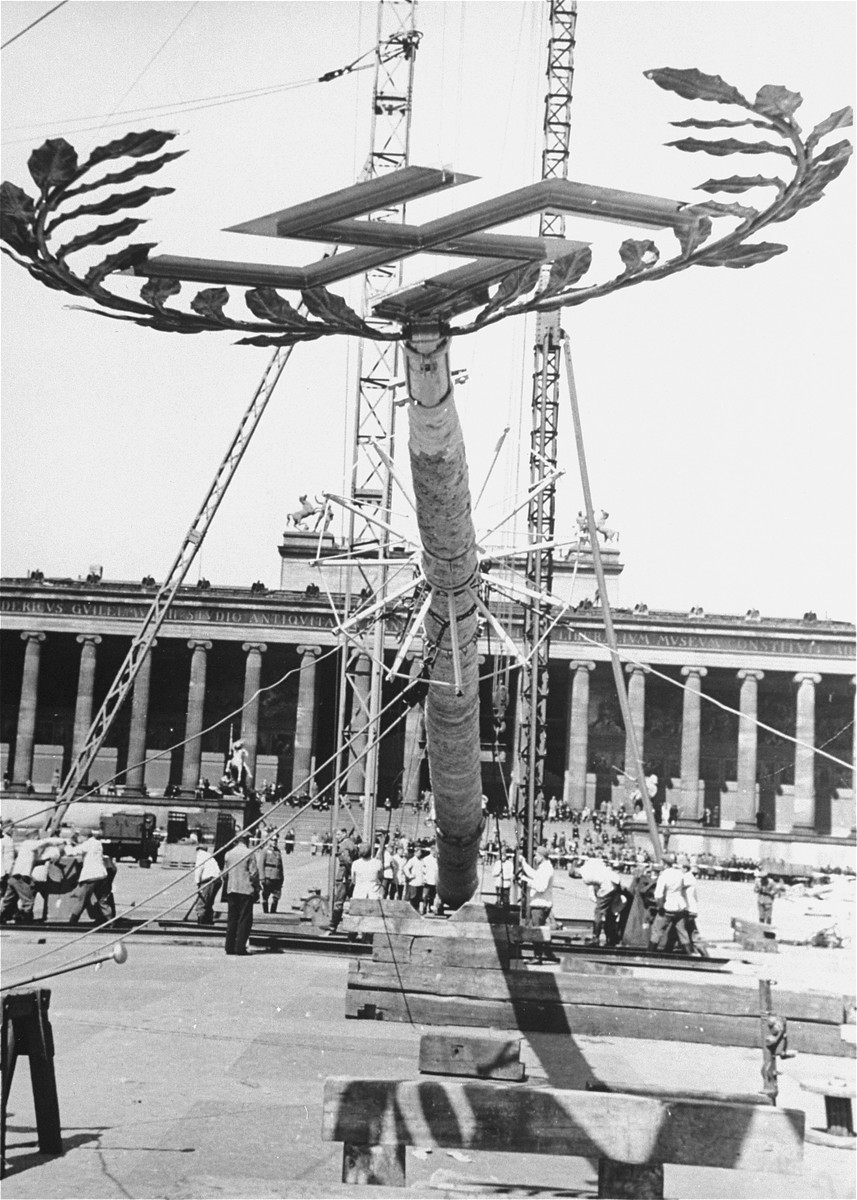 A  Maypole topped with a swastika is raised for a May Day parade in the Lustgarten in Berlin. [LCID: 83796]