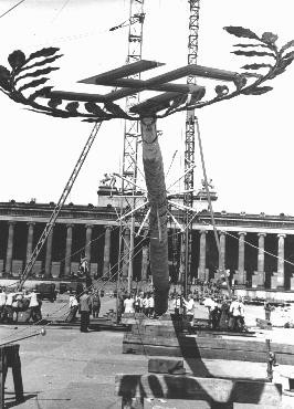 A  Maypole topped with a swastika is raised for a May Day parade in the Lustgarten in Berlin. [LCID: 83796]