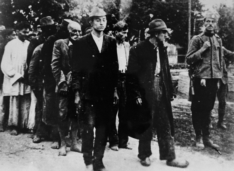 A Serbian gendarme serving the Serbian puppet government led by Milan Nedić escorts a group of Roma (Gypsies) to their execution. Yugoslavia, ca. 1941–1943.