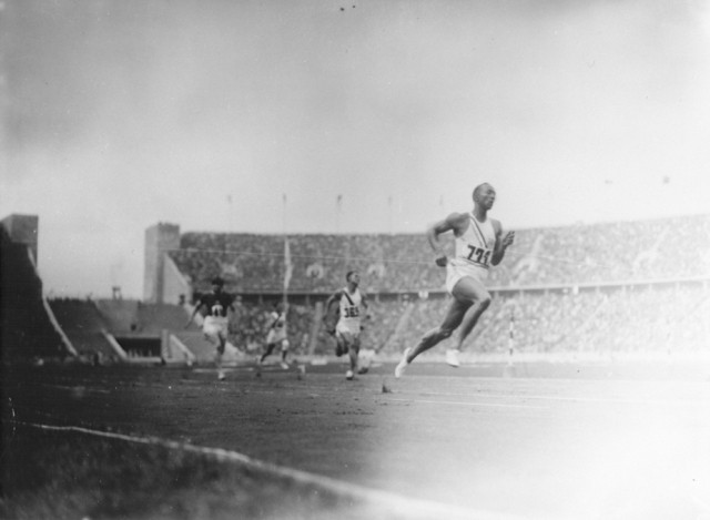 American Olympic runner Jesse Owens and other Olympic athletes compete in the twelfth heat of the first trial of the 100m dash.