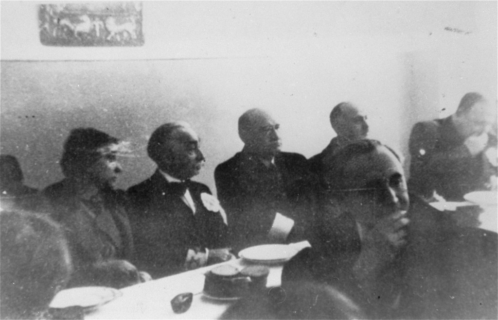A meeting of the Warsaw Jewish council. Sitting behind table, 2nd to 4th from left: industrialist Abraham Gepner; chairman Adam Czerniakow; ...