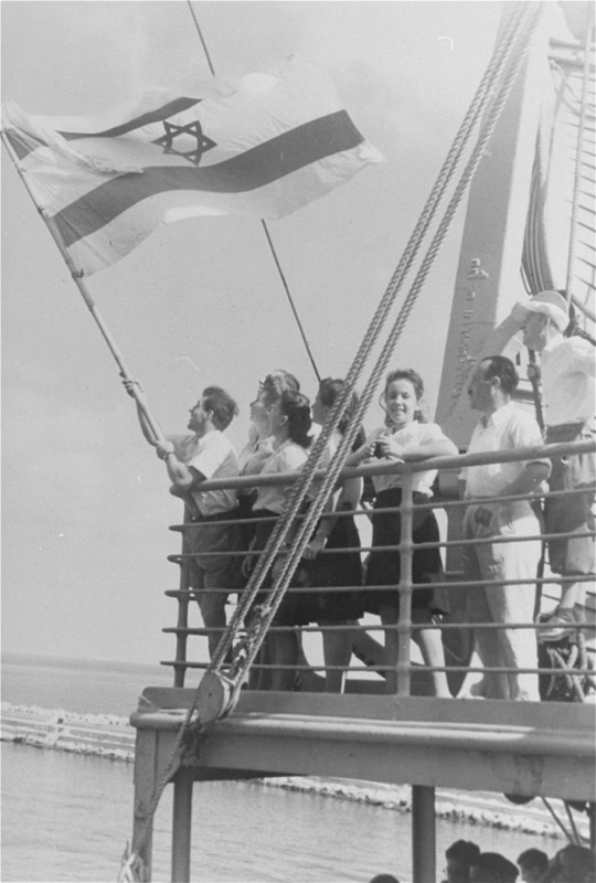Jewish refugee children unfurl the Jewish flag as they arrive at the Haifa port aboard Aliyah Bet ("illegal" immigration) ship SS "Franconia."