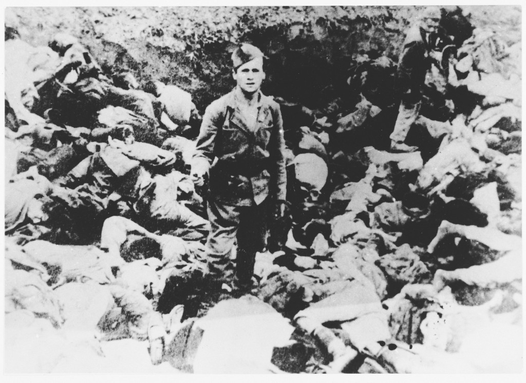 A Ustasa (Croatian fascist) guard stands amid corpses at the Jasenovac concentration camp, Yugoslavia, 1942. [LCID: 64309]