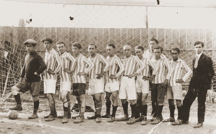 Members of a soccer team in Bitola pose in the goal of a sports field. [LCID: 97811]