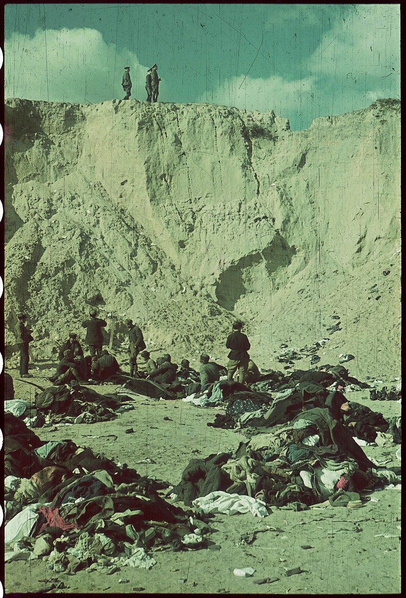 SS men or German officers stand on a cliff near the Babyn Yar killing site