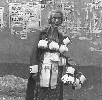 An emaciated woman sells the compulsory Star of David armbands for Jews.