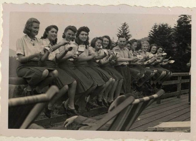 The SS female auxiliaries show with mock sadness that they have finished eating their blueberries, July 22, 1944. [LCID: 34769]