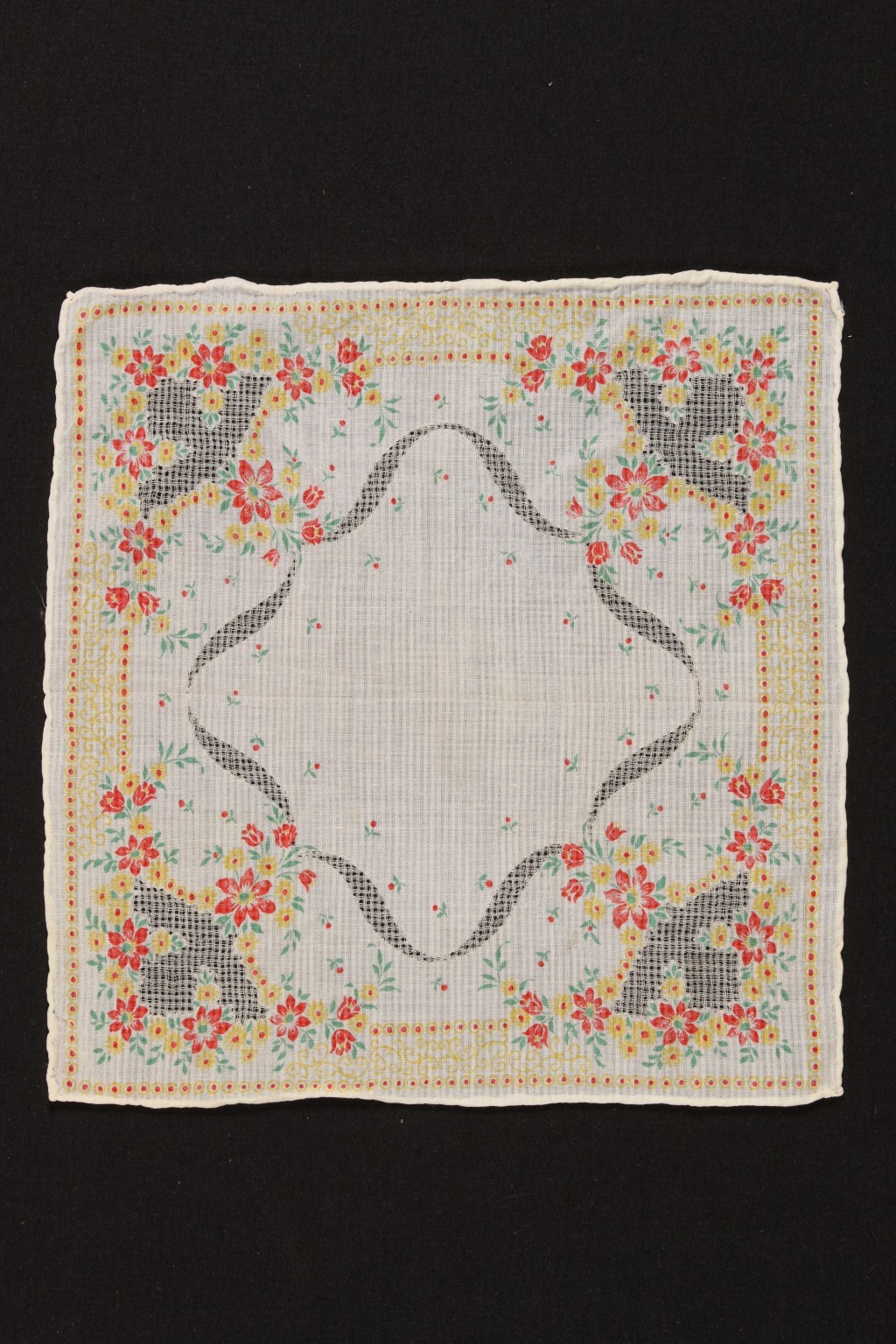 Off white handkerchief with a red and yellow floral pattern that repeats along the corners.