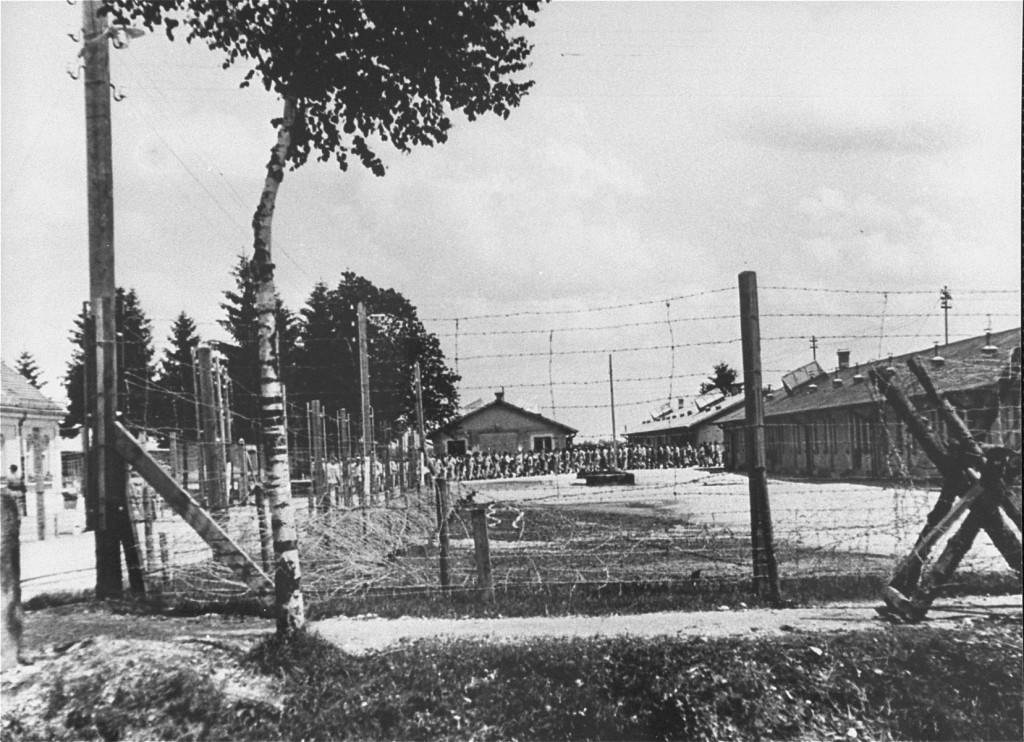 An early view of the Dachau concentration camp. Columns of prisoners are visible behind the barbed wire.