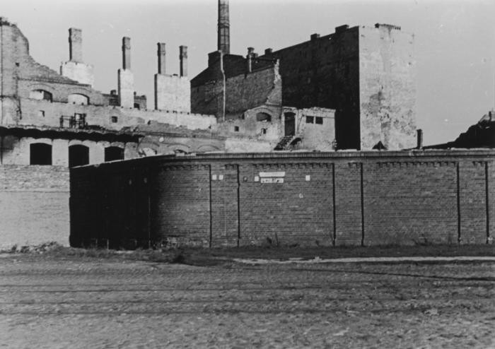 View of the wall surrounding the ruins of the Warsaw ghetto a few months after the ghetto's destruction.