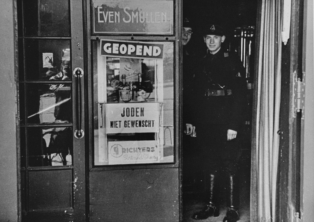 Members of the paramilitary organization of the Dutch Nazi party stand in the doorway of a restaurant. [LCID: 45193]