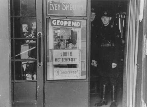 Members of the paramilitary organization of the Dutch Nazi party stand in the doorway of a restaurant.