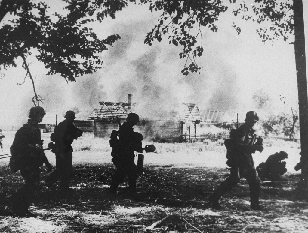 German troops view the burning of a village in the Rogachyevo district of Gomel, Belarus, 1941.
