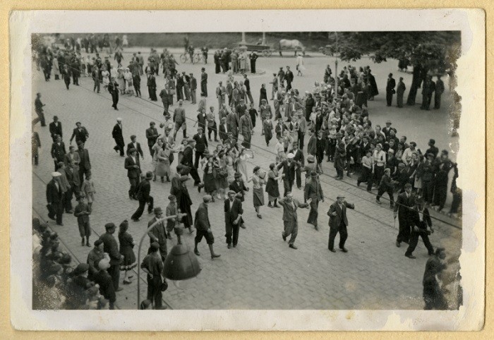 People gathered along the street watch as Jews are rounded up and marched through Lvov.