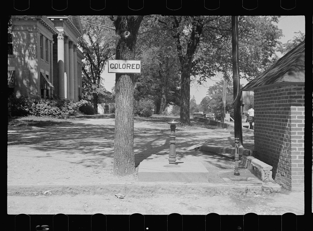 A segregated drinking fountain on the county courthouse lawn in Halifax, North Carolina. Photographed by John Vachon in April 1938.