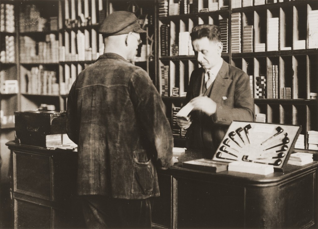 Arthur Lewy attends to a customer in his tobacco shop.