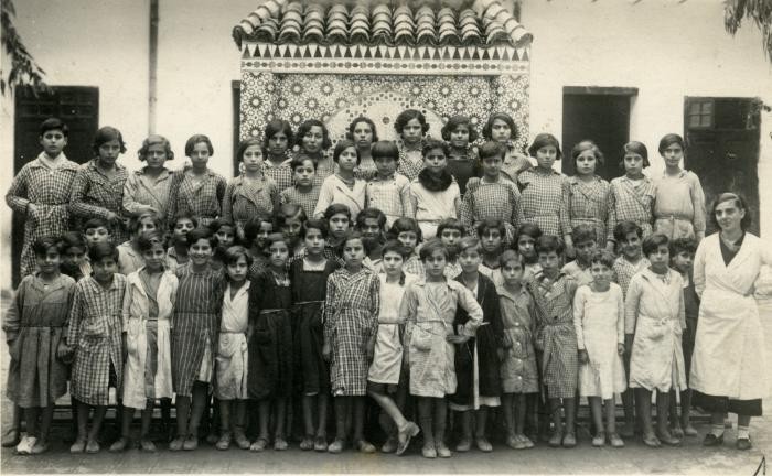 Laurette Cohen (front row, far right) poses with her students at an Alliance Israelite School in Morocco. 1935. 
Laurette was born in Oran, Algeria, 1911. In 1932, she married Prosper Cohen (born in Meknes in 1909). They were both teachers for the Alliance Israelite Universelle Schools in Morocco. Their daughter, Mathilde, was born in Tangiers on August 31, 1933. Before 1939, the family lived in Meknes and Fez. Later, Laurette and Prosper were sent to teach in other different locations where they were most needed. In 1938, Prosper, began to study law. Mathilde attended a French government school. Though new racial laws led to the expulsion of most Jewish children, she was allowed to continue due to the fact that her parents were teachers. 