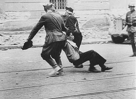 German soldier watches Ukrainian civilians drag a Jew down a street in Lvov.