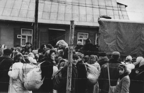 Jewish men, women, and children boarding trucks during deportations from the Kovno ghetto.
