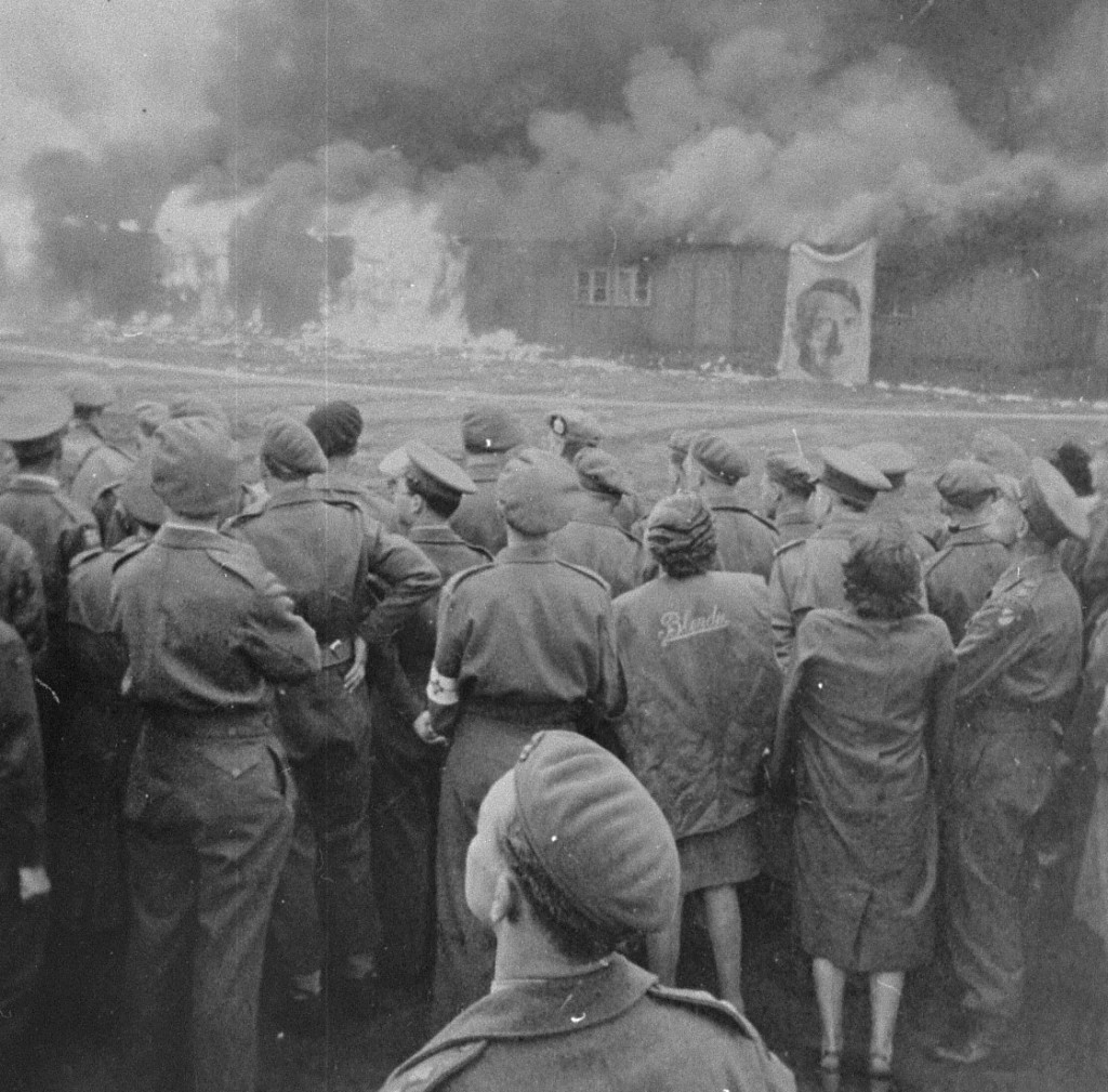 Soon after the liberation of Bergen-Belsen, British soldiers watch as the camp is burned to the ground to prevent the spread of ...