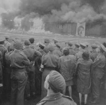  Soon after the liberation of Bergen-Belsen, British soldiers watch as the camp is burned to the ground to prevent the spread of ...