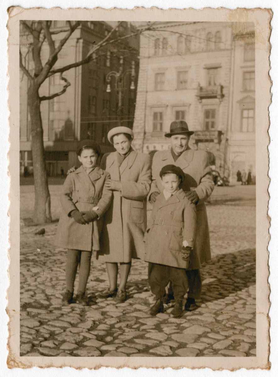 The Chiger family stands on a street in Krakow after the war