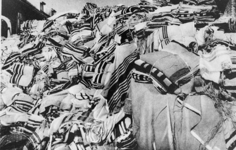 Piles of prayer shawls that belonged to Jewish victims, found after the liberation of the Auschwitz camp. [LCID: 85743]