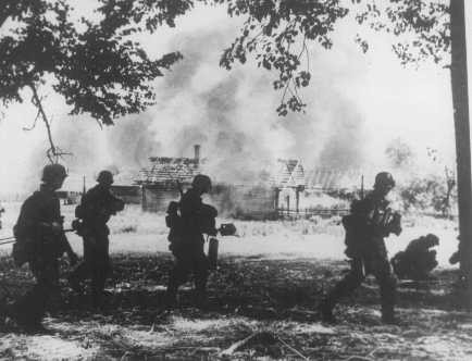 <p>German soldiers near a village in flames. Gomel, Soviet Union, 1941.</p>