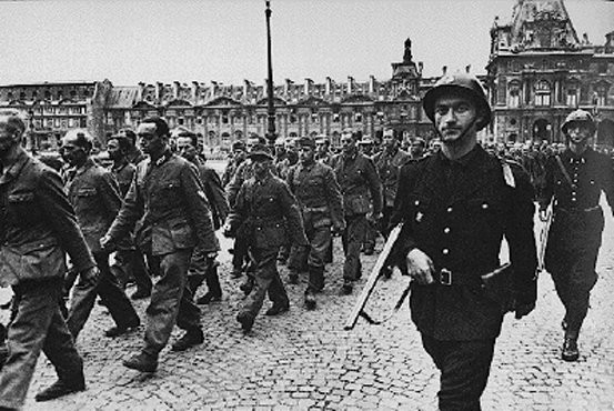French soldiers guard German prisoners outside the Louvre.