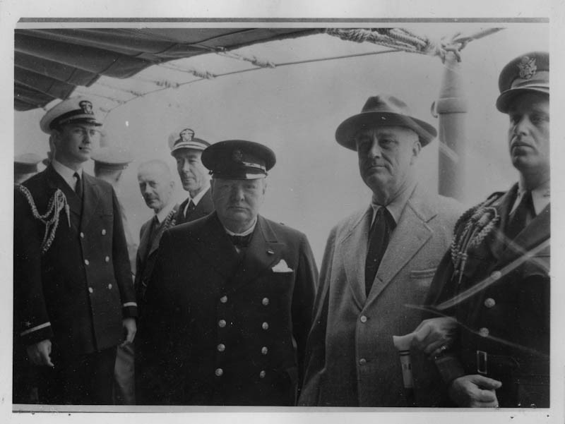 President Franklin D. Roosevelt and British Prime Minister Winston Churchill during the Atlantic Conference on Placentia Bay in Newfoundland, Canada. Also pictured in the foreground are the president’s sons. August 9, 1941.