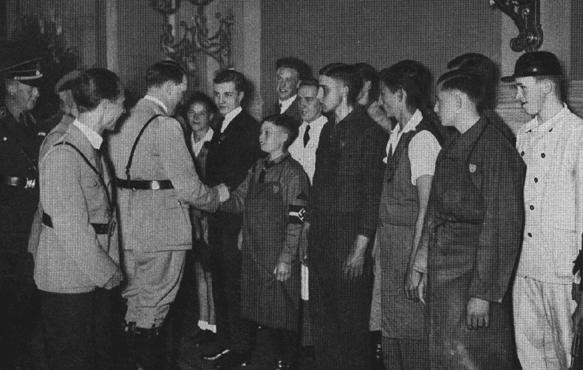  During May Day celebrations, Adolf Hitler greets a group of young workers in the Reich Chancellery building. [LCID: 08046]