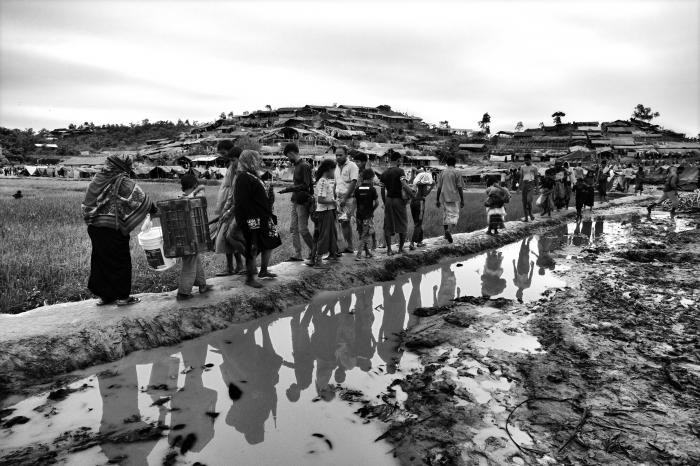 Rohingya walk into a section of a refugee camp