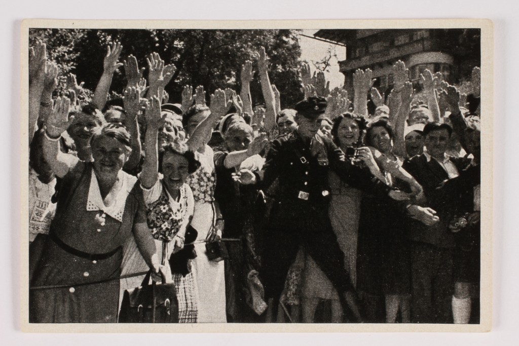 Cigarette card of a crowd of women giving the Nazi salute