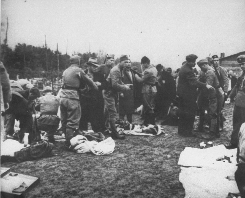 Ustasa (Croatian fascist) guards search prisoners and take their belongings upon arrival at Jasenovac concentration camp. [LCID: 68290c]