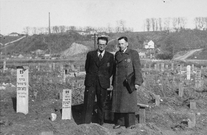 Secretary of the Kovno ghetto Jewich council Avraham Tory stands with Zvi Brik (left), workshop administrator, in the cemetery of ... [LCID: 10915]
