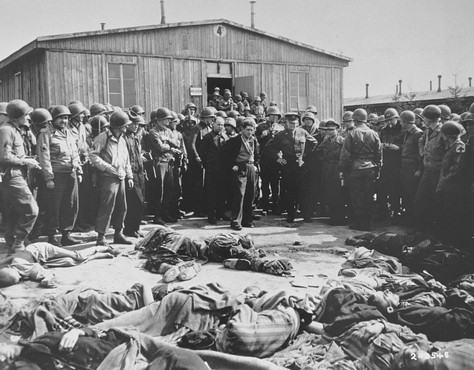 While on a tour of the newly liberated concentration camp, General Dwight Eisenhower and other high-ranking US Army officers view the bodies of prisoners who were killed during the evacuation of Ohrdruf.