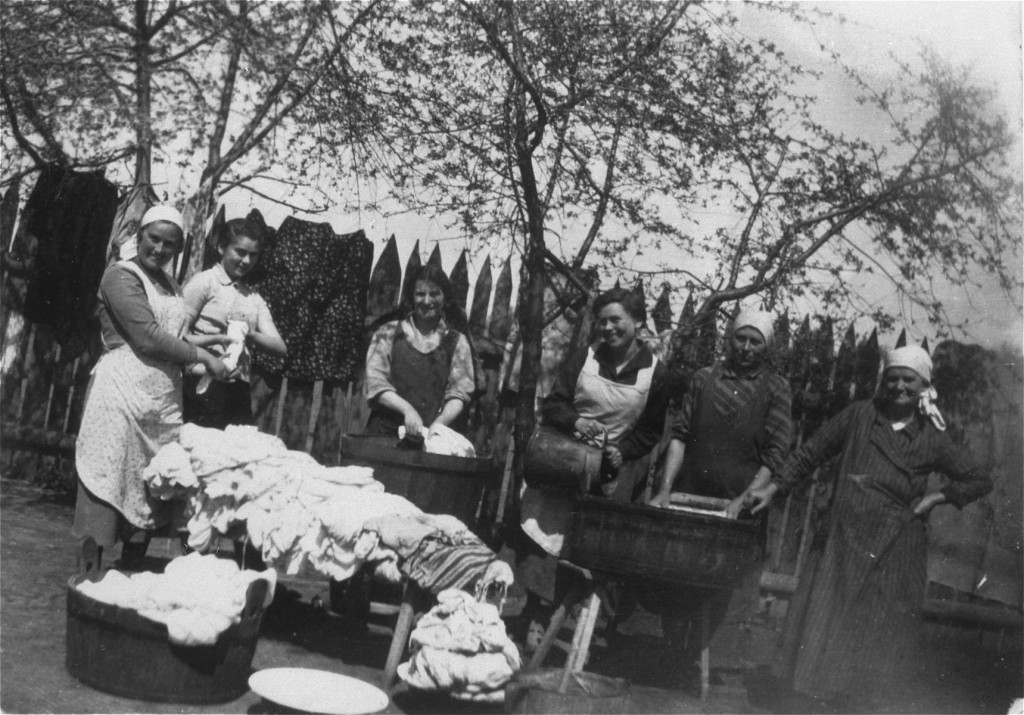 Members of the Saleschutz family do laundry in the yard of their home. [LCID: 67161]
