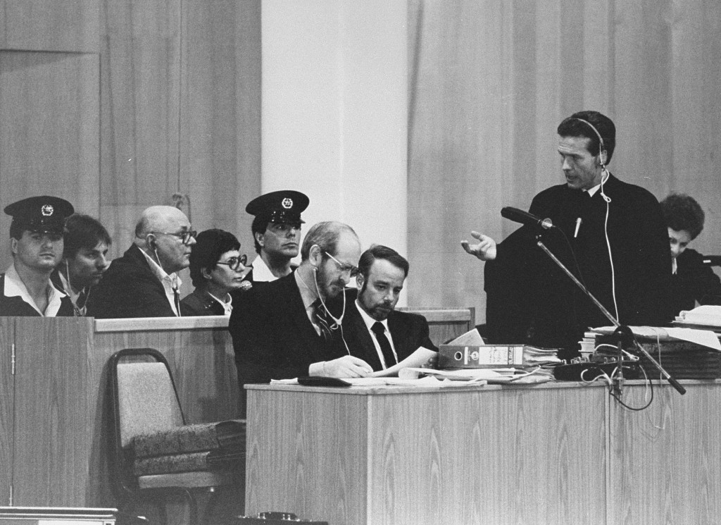 Chief defense attorney Mark O'Conner (standing) addresses a question to John Demjanjuk during Demjanjuk's trial. [LCID: 65259]
