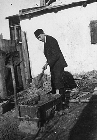 Naftali Saleschutz prepares cement for the foundation of a sukkah (a hut-like structure used to celebrate the Jewish holiday of Sukkot). [LCID: 10879]