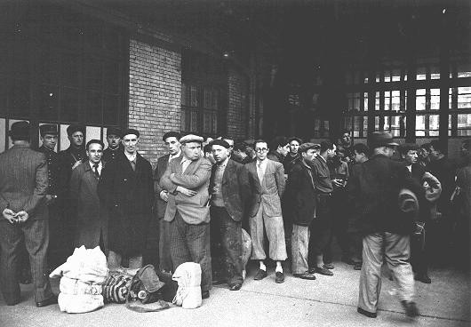 After the first roundup in Paris, French police escort foreign Jewish men from the Japy school to deportation trains at the Austerlitz station.