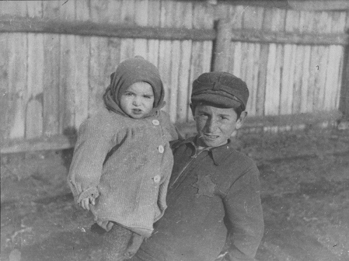 A young boy holding his younger brother in the Kovno ghetto. [LCID: 81172]