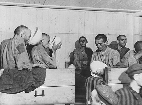 Liberated prisoners at the Ebensee camp. Too weak to eat solid food, they drink a thin soup prepared for them by the US Army. [LCID: 78357]