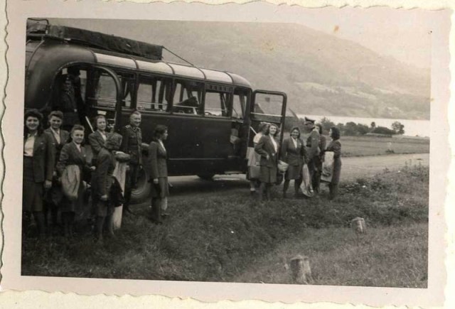 SS female auxiliaries getting off the bus on a day trip in July 1944; this image contrasts starkly with the arrival of a transport of Hungarian men, women, and children in Birkenau in May 1944.