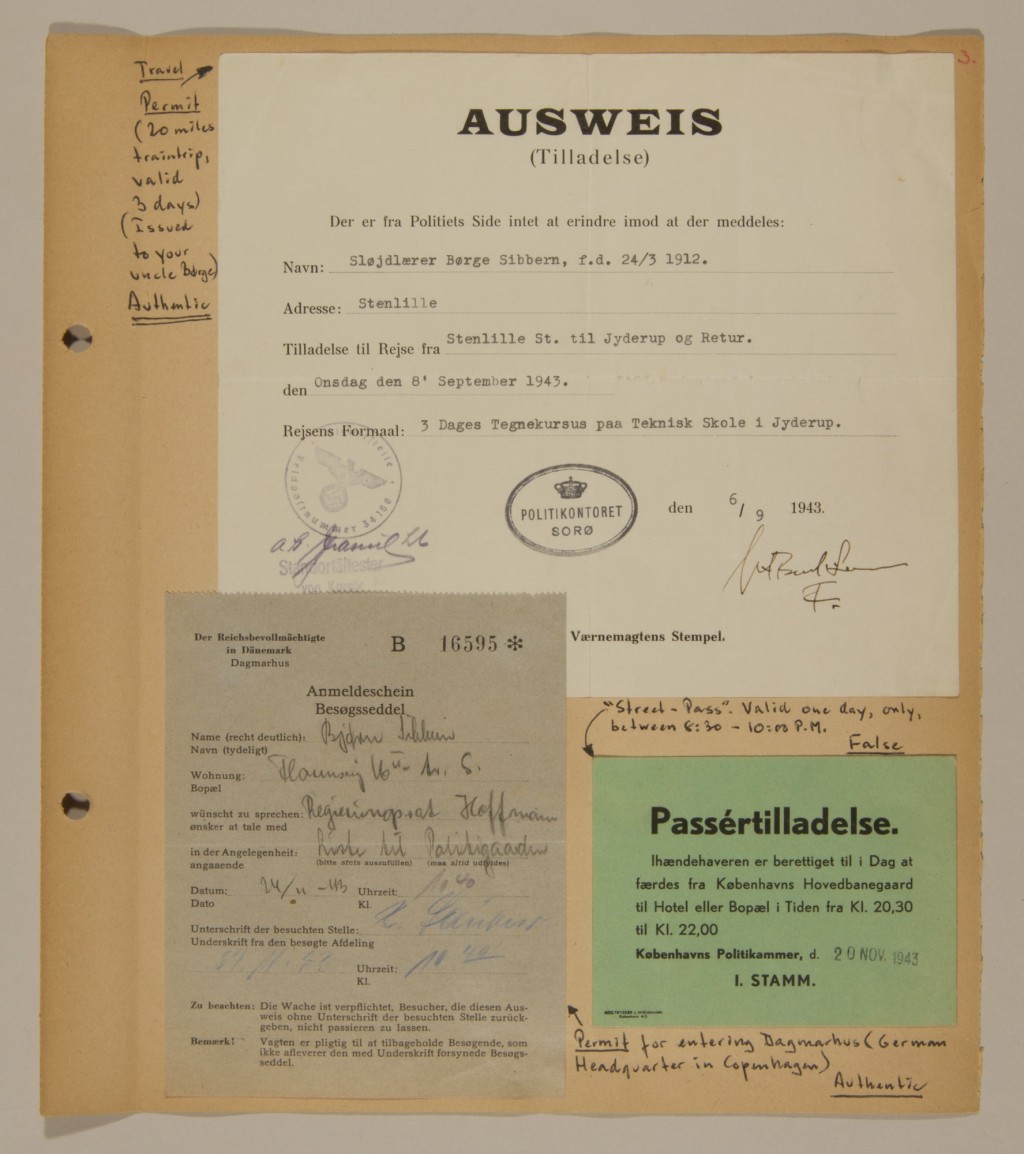 Scrapbook page with handwritten notes in black ink containing several paper passes. A large white pass is glued in the center of the page, with smaller gray and green passes along the bottom.