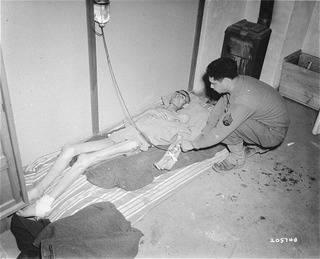 Un soldat américain nourrit par intraveineuse le détenu d’un camp libéré . [LCID: 77602]