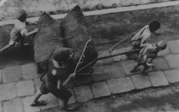 Jewish children forced to haul a wagon. Lodz ghetto, Poland, wartime. [LCID: 10503b]